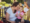 Image of a female Click Rain employee sitting in a lawn chair with a baby on her lap during a picnic