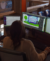 Over the shoulder image of woman working with multiple monitors