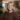 Renae smiling. She has short, wavy blonde hair and is wearing a brown button-up sweater.