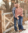 Female employee and her husband pose for a picture in front of a wooden fence during the fall