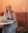 Taylor sits in a booth with her laptop on the table. She's smiling while looking off to the side.