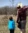 Male employee stops to point to a location on a map while on a hike with his child