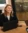 Natalie smiles behind laptop in conference room